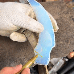 Fitting the handle/tang area on a blue curved crystal blade blank during assembly and finishing