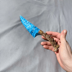 Stoneblade Forge blue opalite crystal dagger with natural antler handle held in hand against gray fabric background
