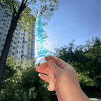 Stoneblade Forge blue opalite crystal dagger with antler handle held up to sunlight outdoors