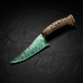 Seafoam-green stone blade dagger with antler handle on dark leather background