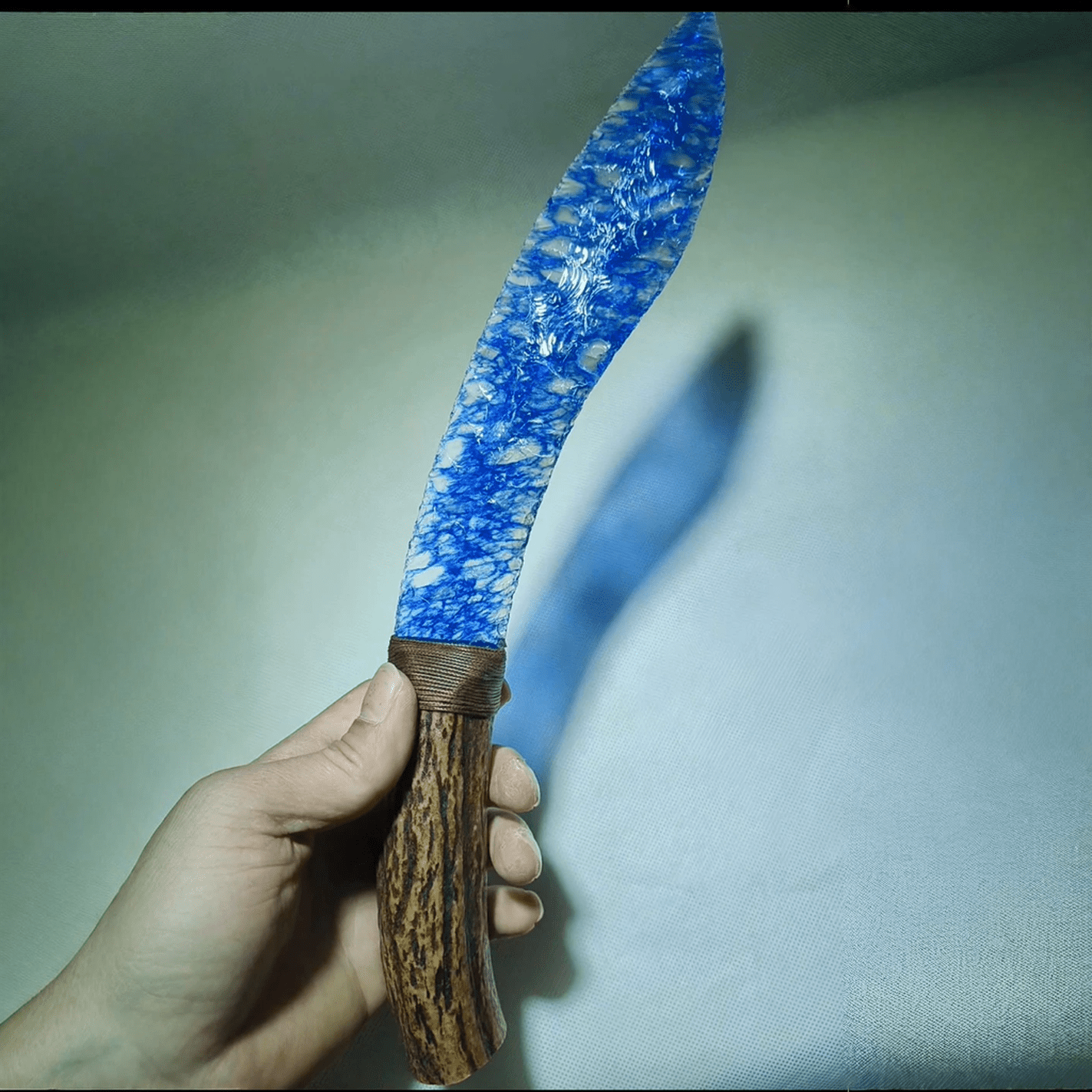 Claw Stone Blade — Abysscrest (Ocean Blue, Crystal), hand-held curved blade close-up