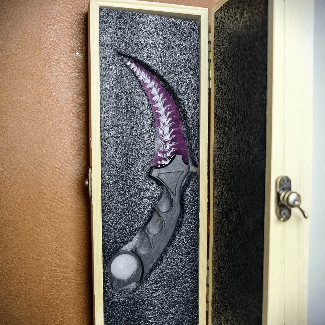 Deep purple crystal claw stone blade in presentation case with foam insert, top view