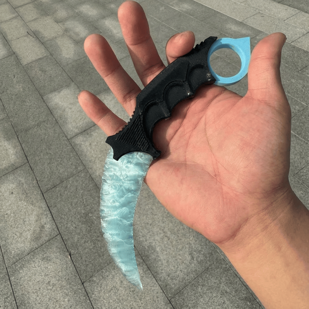 Ice-blue crystal claw stone blade in hand on stone pavement, angled view