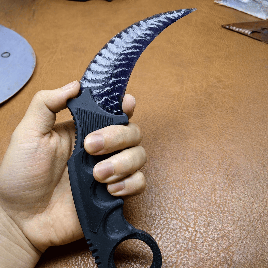 Black crystal claw stone blade in hand, close-up on leather workbench
