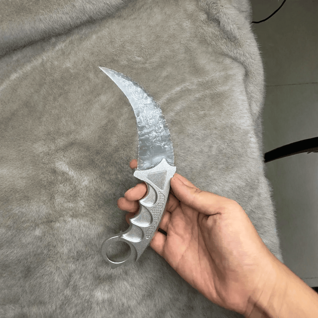 Moonclaw claw stone blade in hand showing metal ring grip and curved edge