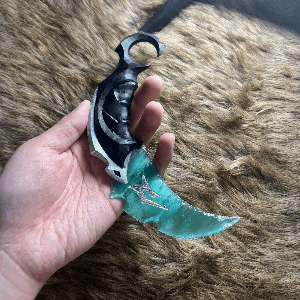 Tidefang Claw Stone Blade in hand showing black ring grip and teal translucent blade