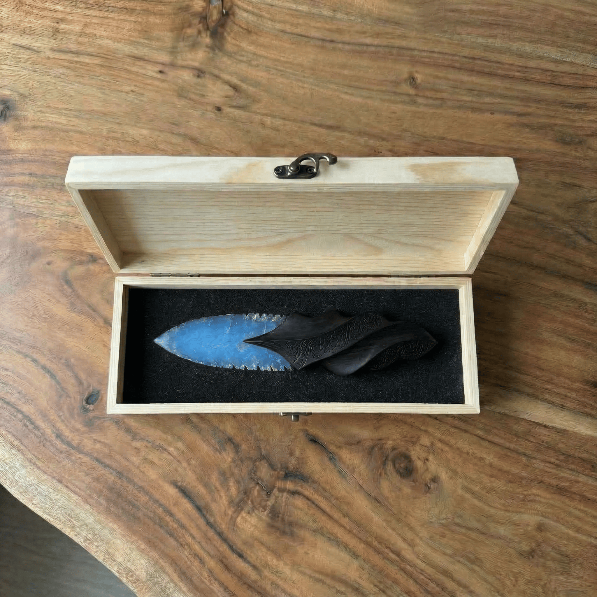 Stoneblade Forge Dagger Stone Blade “Oblivion” — blue knapped-style dagger in an open wooden presentation box with black foam on a rustic wood table.