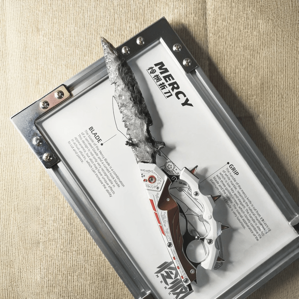 Grey knapped-style dagger with red-and-white mechanical-style handle displayed on the “MERCY” board in a metal frame (Delta Force).