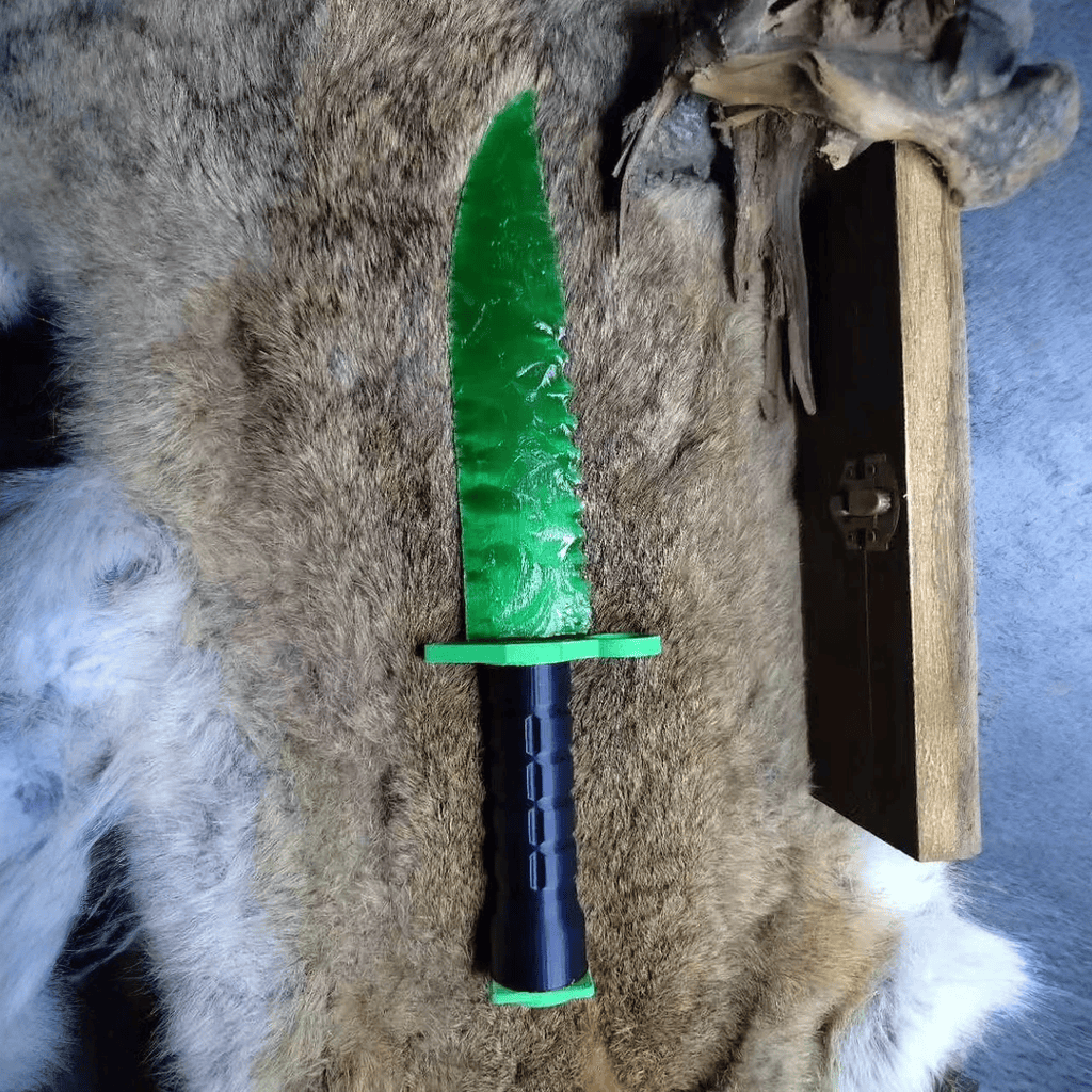 Stoneblade Forge Dagger Stone Blade “Doppler” — full-length display on fur, showing the bright green blade and black military-style grip with green guard.