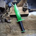 Stoneblade Forge Dagger Stone Blade “Doppler” — angled product shot on fur with rustic props, highlighting the glowing green blade texture and serrated knapped edge profile.