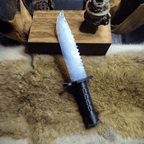 Stoneblade Forge Dagger Stone Blade “Frostveil” — full-length display on fur, showing the frosted blue blade profile and black military-style grip.