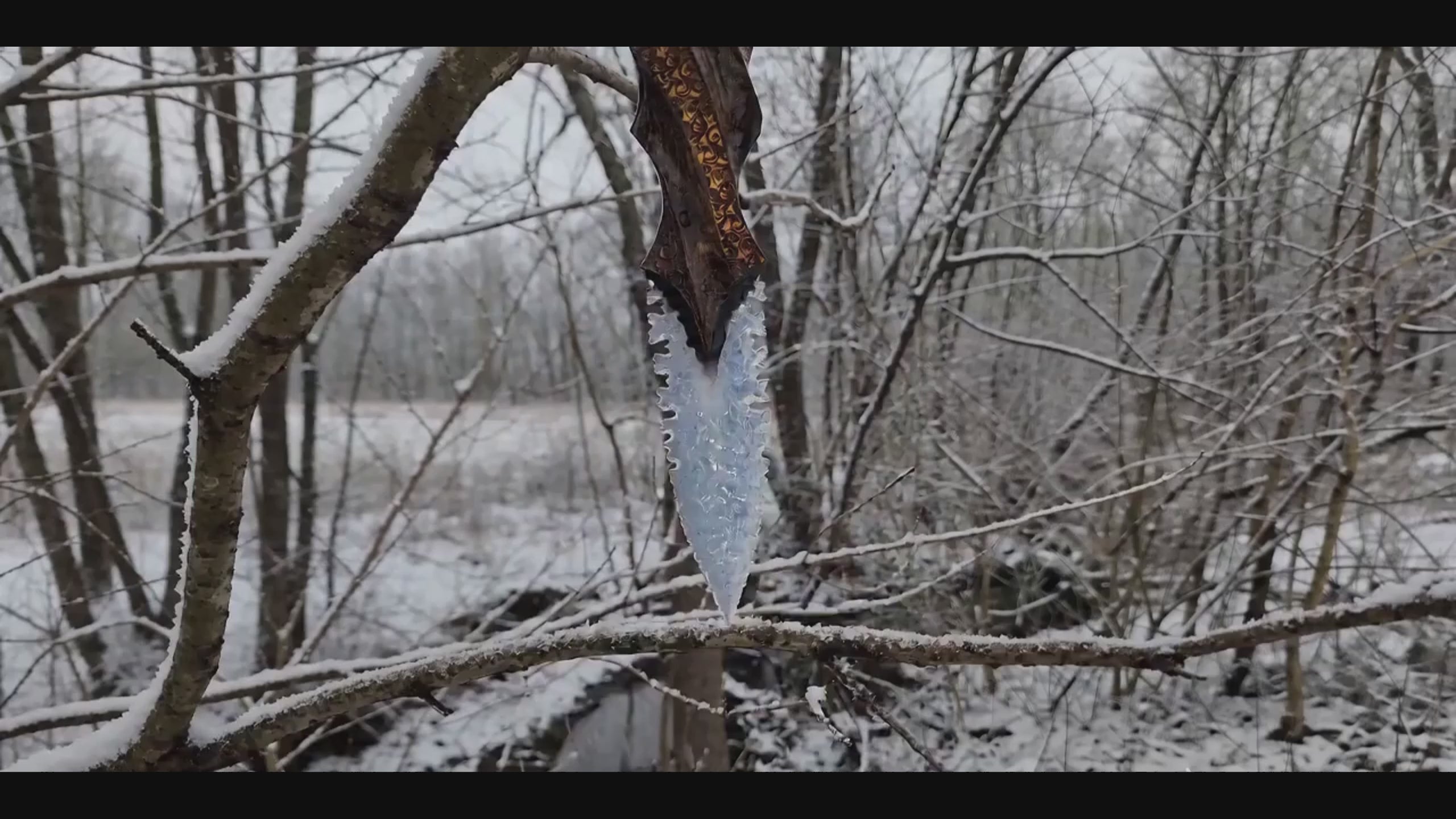 Stoneblade Forge Blade of Oblivion video showing an icy crystal dagger with carved wooden handle held in a snowy forest scene