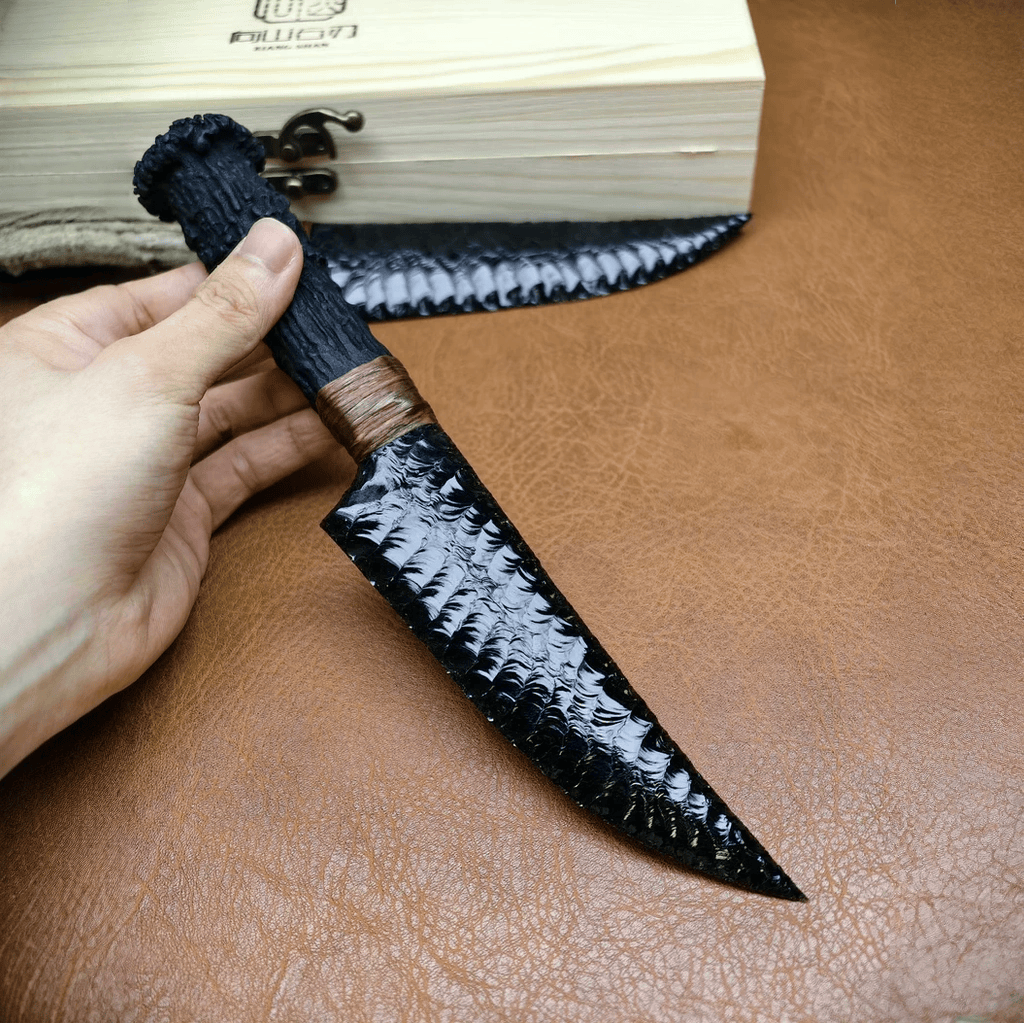 Marauder obsidian crystal stone blade dagger held by handle on brown leather with wooden box in background