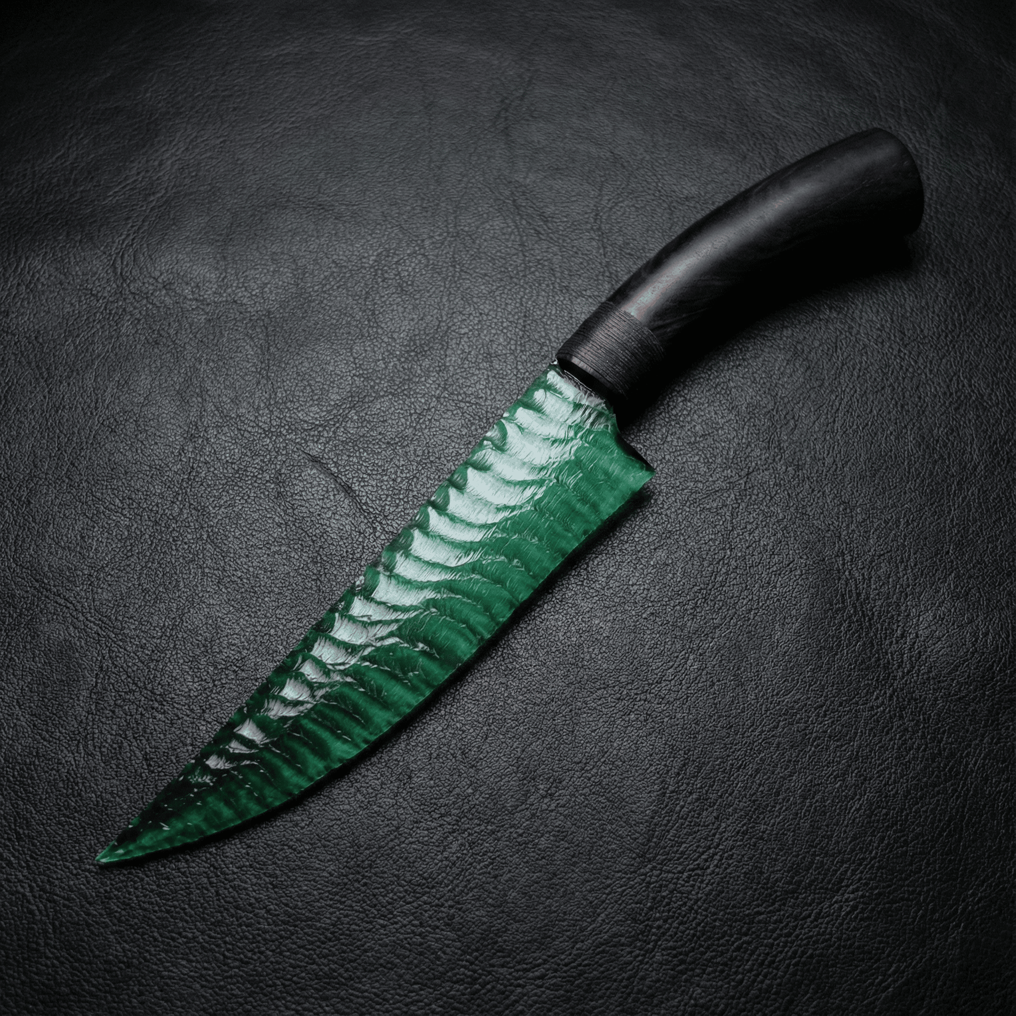 Marauder obsidian stone blade dagger with ebony handle on black leather background